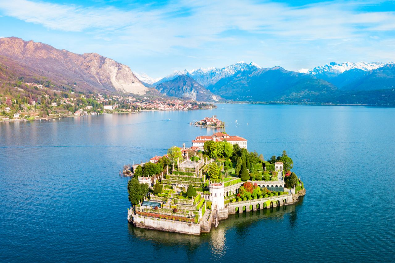 luxury Stresa Lake Maggiore, Borromean Islands private tour, Villa Palazzo Aminta, Lake Maggiore boat excursion, Italian lakes luxury hotel, Luxury lake view room at Villa Palazzo Aminta Hotel Stresa with balcony, Private mahogany boat approaching Isola Bella Borromean Islands, Ten-terraced Italian gardens at Isola Bella Palace Lake Maggiore, White peacock strolling through Isola Bella botanical gardens, Venetian terrazzo floors and marble columns at Villa Aminta lobby, Panoramic view of Stresa and Lake Maggiore from alpine perspective, Baroque palace interior at Isola Bella with priceless art collection, Fresh lake fish dish at Isola dei Pescatori restaurant, Colorful peacocks in botanical gardens at Isola Madre, Private boat cruising Lake Maggiore with alpine mountain backdrop.