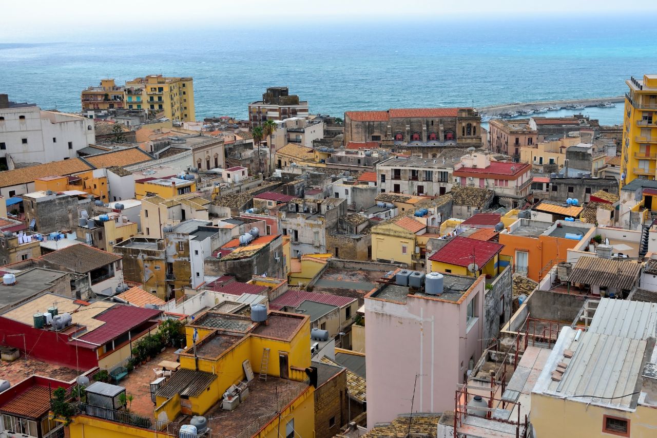 Aerial view of the historic town of Sciacca Sicily on the Mediterranean coast, Luxury thermal spa pool with thermal waters in Sciacca Sicily, Colorful hand-painted Sicilian ceramics in a Sciacca artisan workshop, Fresh seafood display with red prawns and swordfish at Sciacca fish market, Ancient Greek temples at Selinunte archaeological park near Sciacca at sunset, Private boat tour in the turquoise waters of the Stagnone Nature Reserve Sicily, Historic windmills and salt pans at Trapani with sunset colors, Traditional pasta con le sarde dish served in a Sciacca seaside restaurant, Master ceramicist painting a traditional design in his Sciacca workshop.