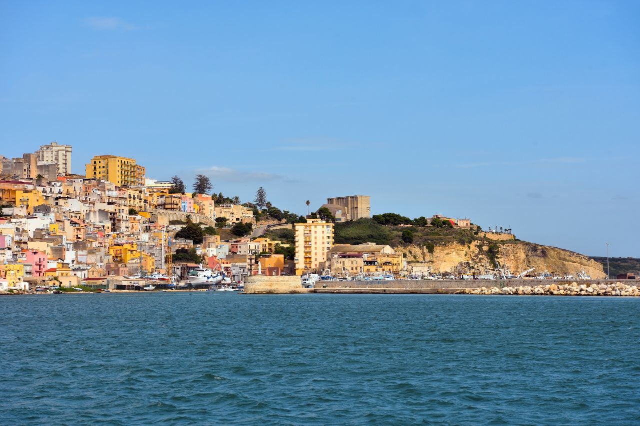 Aerial view of the historic town of Sciacca Sicily on the Mediterranean coast, Luxury thermal spa pool with thermal waters in Sciacca Sicily, Colorful hand-painted Sicilian ceramics in a Sciacca artisan workshop, Fresh seafood display with red prawns and swordfish at Sciacca fish market, Ancient Greek temples at Selinunte archaeological park near Sciacca at sunset, Private boat tour in the turquoise waters of the Stagnone Nature Reserve Sicily, Historic windmills and salt pans at Trapani with sunset colors, Traditional pasta con le sarde dish served in a Sciacca seaside restaurant, Master ceramicist painting a traditional design in his Sciacca workshop.