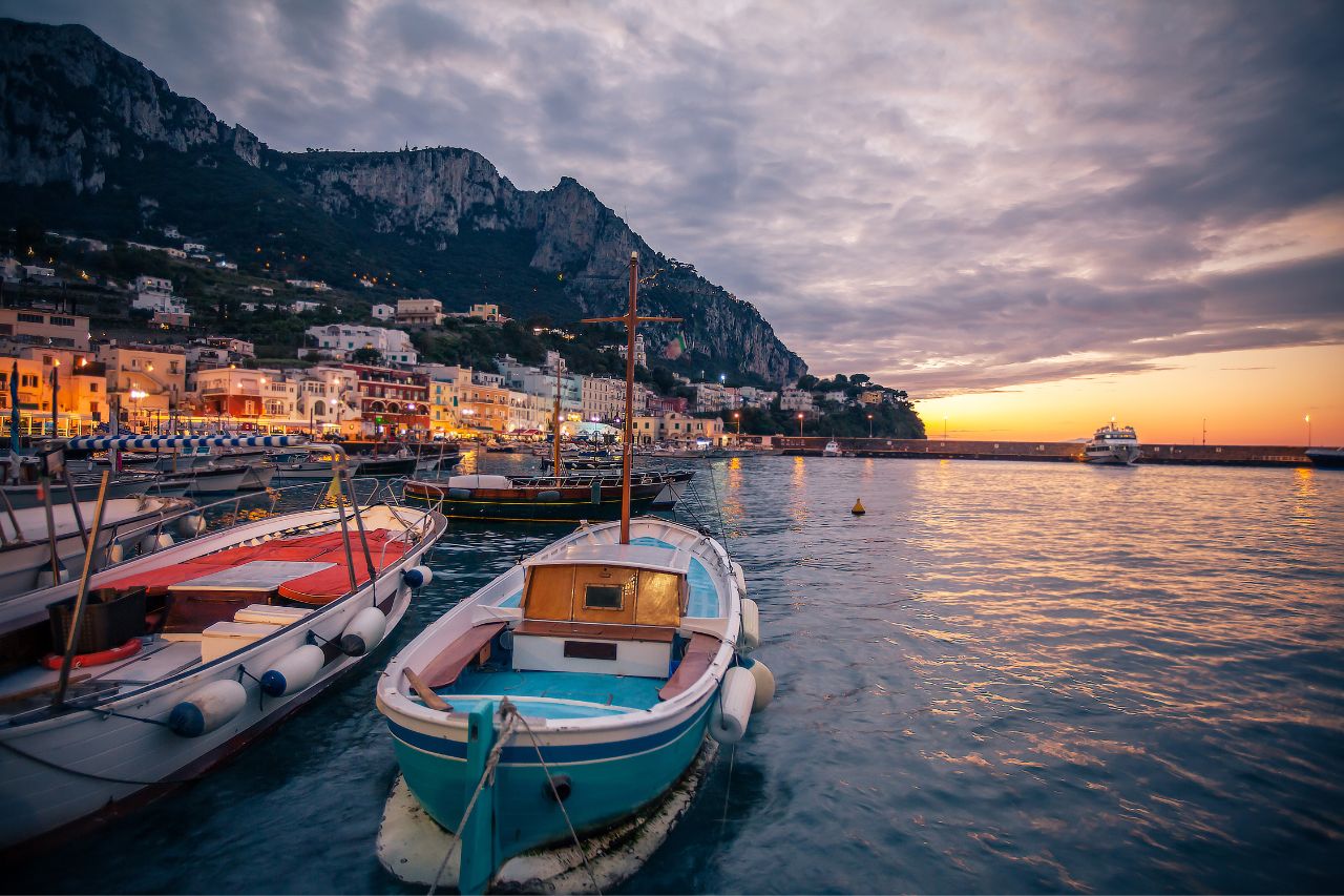 Iconic Faraglioni limestone sea stacks during private luxury boat tour Capri Island Italy, Blue Grotto sea cave with ethereal sapphire light Capri Mediterranean, Five-star Hotel Caesar Augustus perched on 300-meter cliffs Anacapri Bay of Naples view