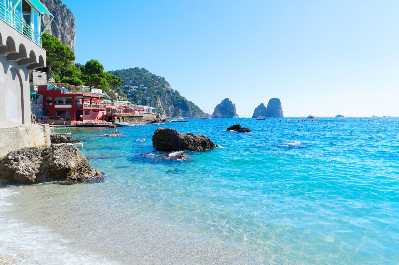 Iconic Faraglioni limestone sea stacks during private luxury boat tour Capri Island Italy, Blue Grotto sea cave with ethereal sapphire light Capri Mediterranean, Five-star Hotel Caesar Augustus perched on 300-meter cliffs Anacapri Bay of Naples view