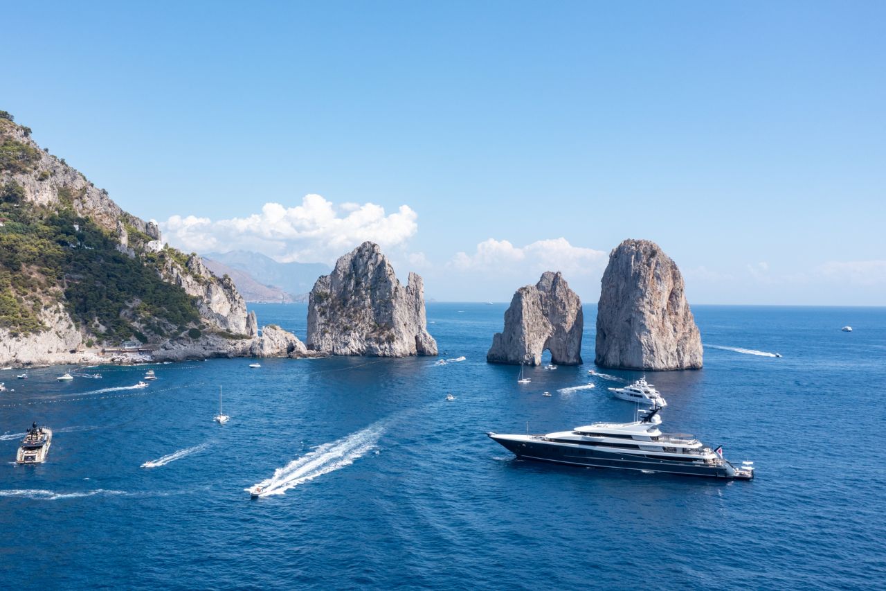 Iconic Faraglioni limestone sea stacks during private luxury boat tour Capri Island Italy, Blue Grotto sea cave with ethereal sapphire light Capri Mediterranean, Five-star Hotel Caesar Augustus perched on 300-meter cliffs Anacapri Bay of Naples view